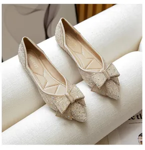 Close-up of elegant French style pointed toe flat shoes with sparkly crystal bow decoration