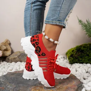 Détail de baskets en mesh rouge respirant avec imprimé léopard et semelles blanches épaisses