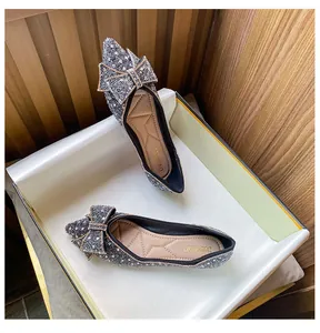 Detailed top view of sparkling silver glitter pointed-toe flats with bow decoration
