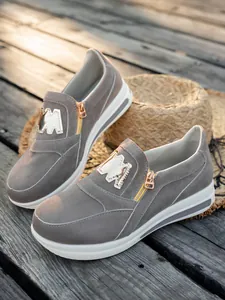 Seitenansicht graue Wildleder-Sneaker mit goldenem Reißverschluss und Plateausohle.