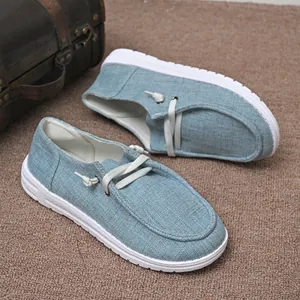Detail view of light blue denim fabric women's casual loafers with white soles