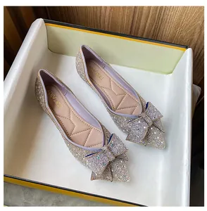 Detail of sparkly pointed-toe flat shoes with elegant bow and cushioned insole