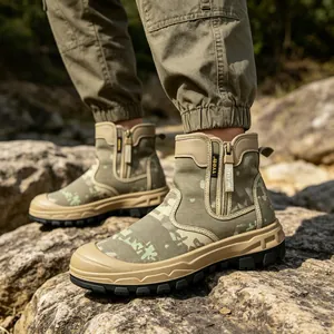 Side view detail of camouflage outdoor combat boots with side zipper on rugged rocks