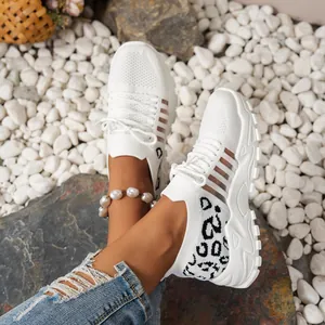 Gros plan de baskets blanches en maille respirante avec talon imprimé léopard chic.
