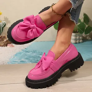 Detaillierte Ansicht der pinken Plateau-Loafer aus Lackleder mit großer Schleife