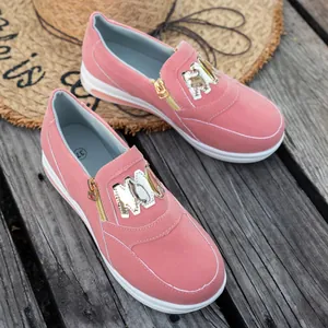Nahaufnahme der rosa Wildleder-Sneaker mit goldenem Reißverschluss und Dekor