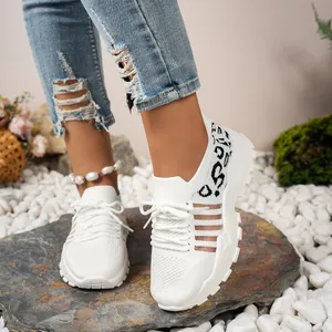 Gros plan sur les baskets blanches en mesh pour femmes avec un motif latéral unique