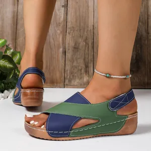 Détail de sandales compensées pour femmes avec un design bicolore vert et bleu marine