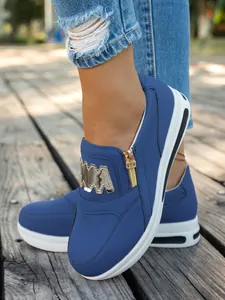 Blaue Damen-Sneaker mit Plateausohle und Reißverschluss-Detail auf einem Holzsteg