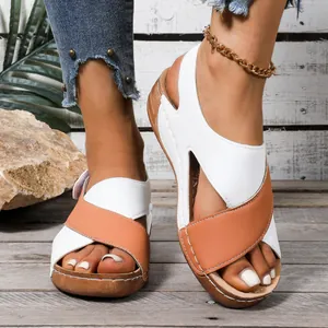 Vue détaillée de sandales compensées pour femmes blanches et marron à brides croisées.