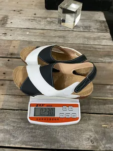 Mesure du poids de sandales à plateforme bicolores avec brides croisées sur une balance