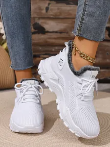 Detailopname van witte dames wintersneakers met grijze bontvoering en een zachte zool