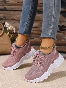 Detailweergave van roze gebreide sneakers met warme imitatiebontvoering en witte zool
