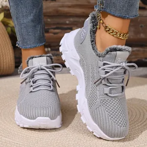 Detailweergave van grijze vetersneakers met zachte bontvoering en dikke witte zolen