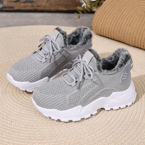 Detail van grijze wintersneakers voor dames met warme voering van imitatiebont en breisel.