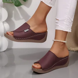 Vista lateral de sandalias de cuña granate con diseño peep-toe y plataforma