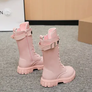 Detailed view of pink girls mid-calf Martin boots with star straps and chunky lug soles