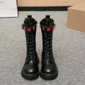 Detailed front view of stylish girls black leather tall boots with red star buckle straps