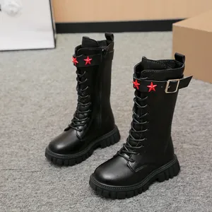 Macro view of black girls' knee-high leather Martin boots with red star buckle details
