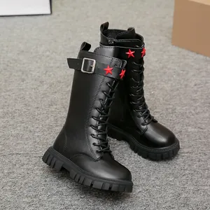 Detailed view of girls' black tall Martin boots with red star studs and buckles