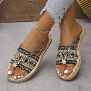 Primer plano de estas chanclas de paja trenzada para mujer con adornos florales