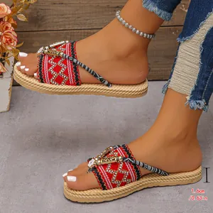 Primer plano de sandalias étnicas rojas con suelas de paja trenzada y metal