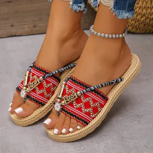 Primer plano de chanclas de cuña de paja para mujer con patrones rojos bohemios para la playa