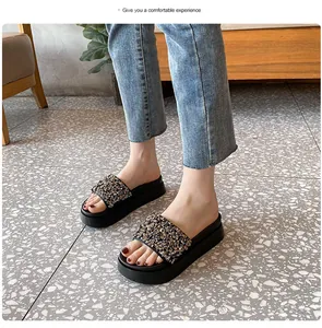 Detailopname van stijlvolle zwarte platformsandalen met glinsterende strass en kralen.