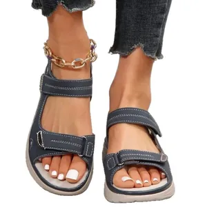 Dettaglio di sandali sportivi blu da donna con zeppa e cinturini in velcro.