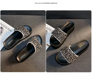 Detailopname van zwarte platform slippers met fonkelende kralen en strass decoratie