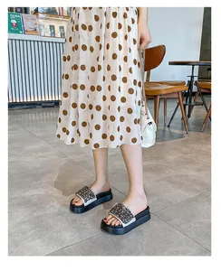 Detailopname van platform slippers met fonkelende strass kralen in een café setting