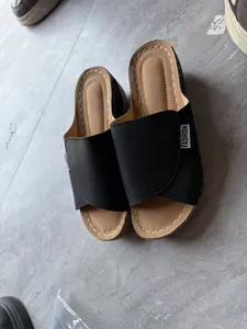Detalle de sandalias de cuña negras con suela de plataforma y diseño de punta abierta