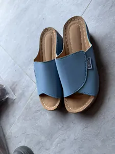 Detalle de las sandalias de cuña azul claro con suela gruesa y diseño de punta abierta
