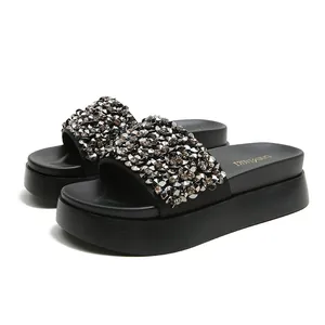 Stijlvolle zwarte platform slippers met fonkelende strass-steentjes en kralenversiering.
