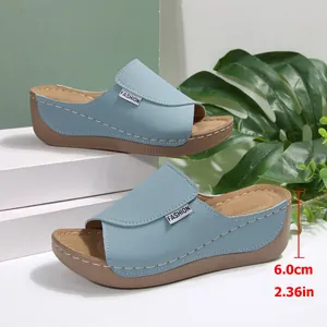 Detalle de sandalias con cuña azul claro que muestran suela de 6 cm y punta abierta