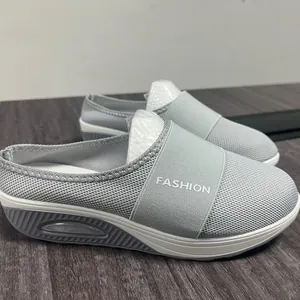 Close-up view of grey mesh wedge mule slippers with air cushion sole for women.