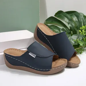 Elegante vista lateral de sandalias con cuña azul marino y detalles de costura blanca