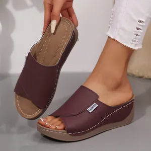Detalle de sandalias de cuña color burdeos con costuras blancas y etiqueta FASHION