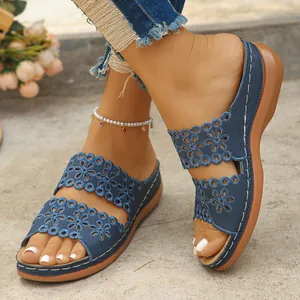 Detailansicht blauer Keilsandaletten aus Denim mit retro floralem Hohlmuster-Design.