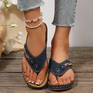 Chanclas con cuña azul marino y tiras perforadas con detalles metálicos de mujer.