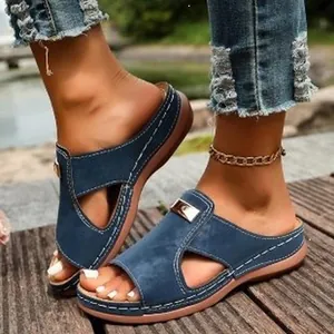 Vue détaillée de sandales compensées élégantes en daim bleu avec boucle en métal doré.