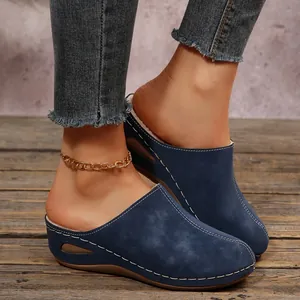 Elegant navy blue wedge mules with white stitching and warm fleece lining on model