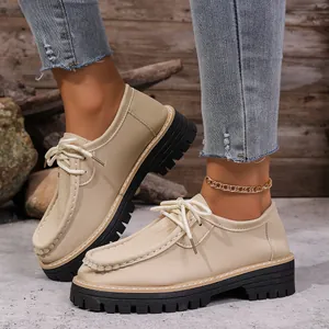 Vue détaillée au pied de mocassins à plateforme rétro de style britannique beige à lacets