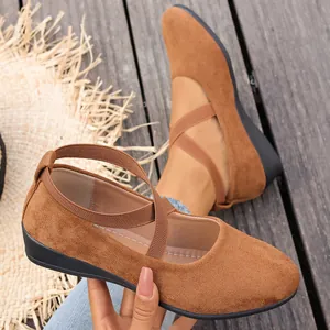 Détail de chaussures plates en daim marron pour femmes avec brides croisées élastiques