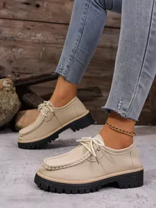 Détail de mocassins à lacets beiges rétro avec semelles plates-formes noires épaisses