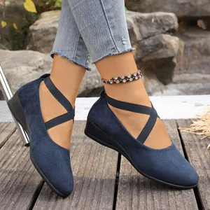 Détail d'escarpins compensés bleu marine avec brides croisées élastiques et talon compensé.