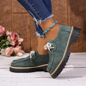 Vue détaillée des mocassins en daim vert style britannique avec semelle plateforme