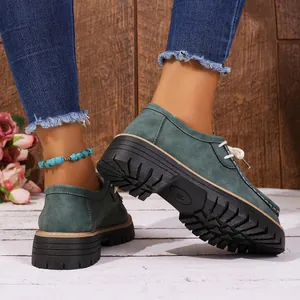 Détail des mocassins en daim vert foncé avec semelles compensées antidérapantes