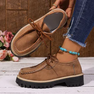 Gros plan de mocassins marron aspect daim avec semelles crantées et surpiqûres.