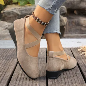Vue détaillée de chaussures compensées en daim beige élégantes avec sangles croisées aux pieds.